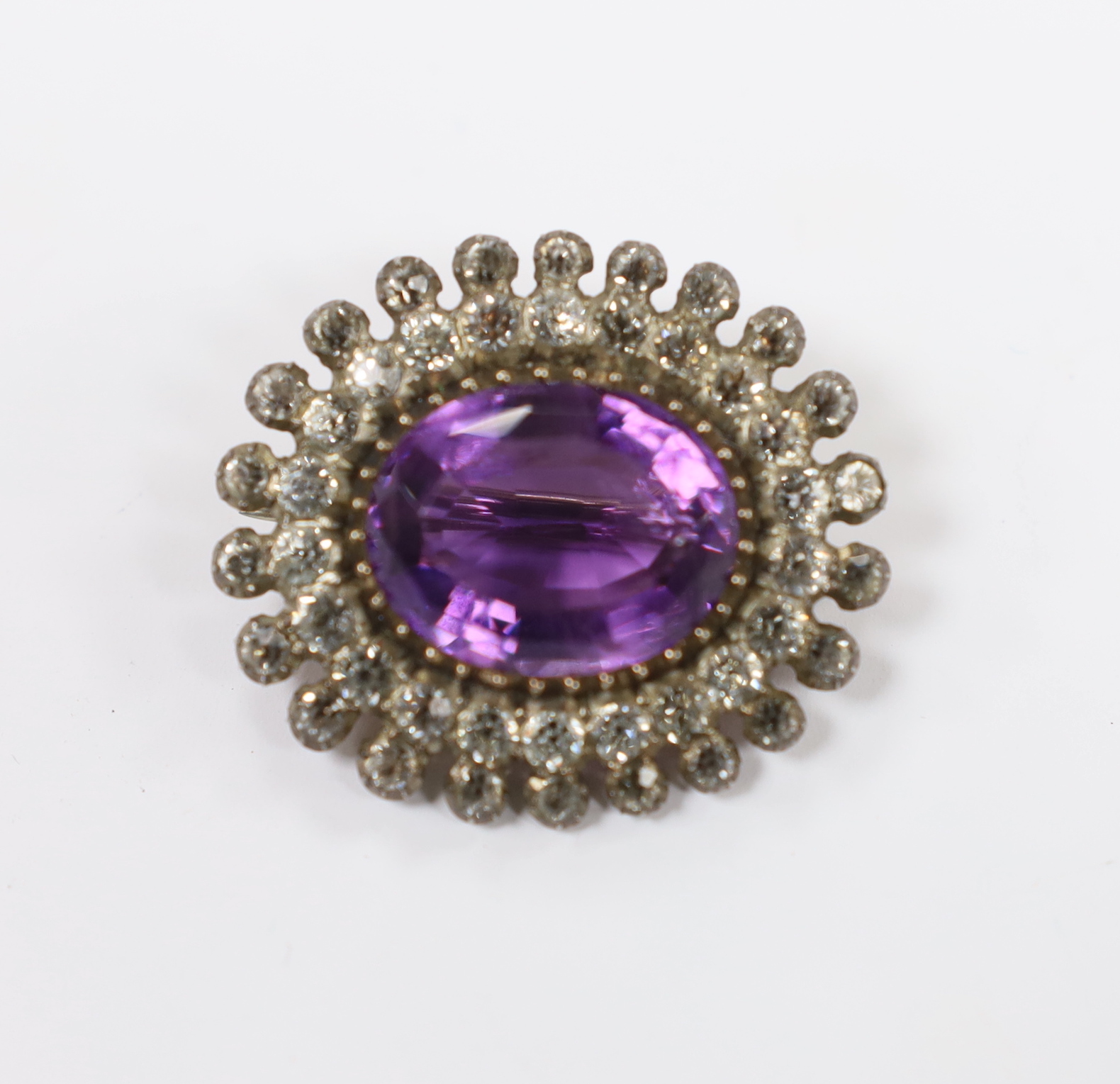 An early 20th century yellow and white metal, amethyst and paste set oval cluster brooch, 33mm.